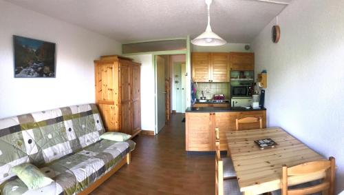 a living room with a couch and a table at studio 4 personnes rez de jardin a Ancelle 05260 in Château-dʼAncelle