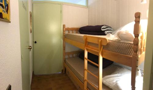 a room with two bunk beds and a hallway at studio 4 personnes rez de jardin a Ancelle 05260 in Château-dʼAncelle