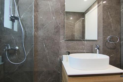 a bathroom with a white sink and a shower at Phaedrus Living: City View Anna Residence 101 in Limassol
