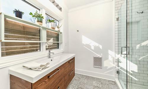 uma casa de banho com um lavatório e uma cabina de duche em vidro. em Flats South em Wellington