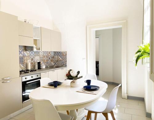 - une cuisine blanche avec une table et des chaises blanches dans l'établissement Paggeria Apartment, à Parme