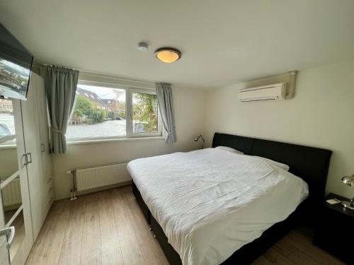 een slaapkamer met een groot bed en een raam bij Woonboot Irene in Alkmaar