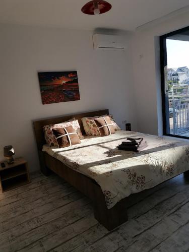 a bedroom with a large bed with a large window at Rimimi Apartamente in Mamaia Nord