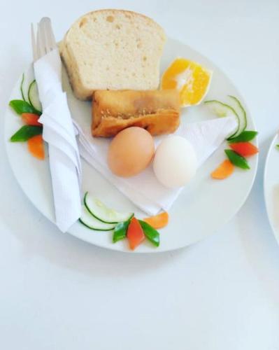a plate with eggs and bread and vegetables on it at Johnsons StopPoint in Zame