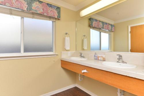 Cayucos Beach Inn في كايوكوس: حمام مغسلتين ومرآة
