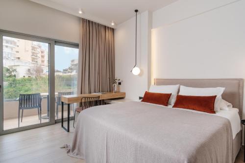 una camera con letto, scrivania e finestra di The City Hotel & Suites a Rethymno