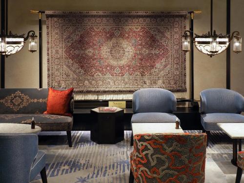 a living room with a rug and chairs and a tapestry at Dhawa Yura Kyoto - Banyan Tree Group in Kyoto
