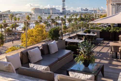 a couch on a balcony with a view of the city at Duquesa de Cardona Hotel 4 Sup by Duquessa Hotel Collection in Barcelona