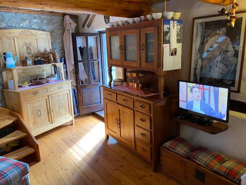 a living room with a tv on a wooden dresser at Casa Ornella - Baita Pra Sec in Montita