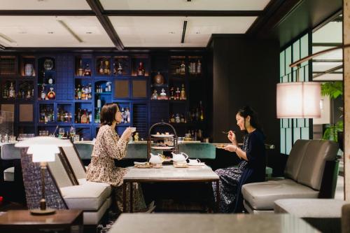 two women sitting at a table in a bar at Dhawa Yura Kyoto in Kyoto