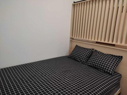 a bed in a room with two pillows and a radiator at Apartemen MAJ at Ecohome Citra Raya in Nalagati