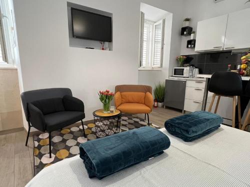 a living room with two chairs and a kitchen at Apartments Noa Old Town in Dubrovnik