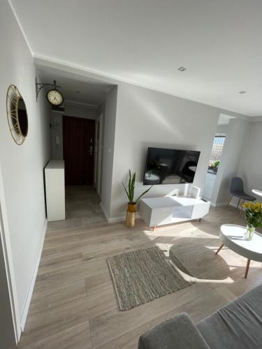 una sala de estar con un sofá y una mesa en LUXURY WHITE APARTMENT by Marta, en Radom