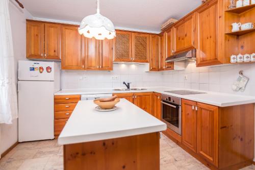 - une cuisine avec des placards en bois et un réfrigérateur blanc dans l'établissement Panoramic Forest Chalet Bled Lake View, à Bled