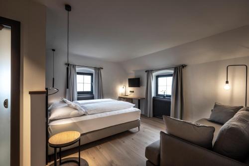 um quarto com uma cama e um sofá em Ansitz Fonteklaus em Chiusa