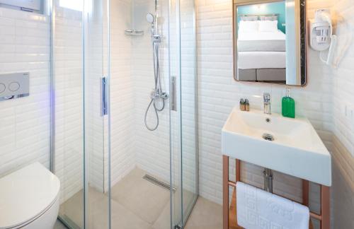 uma casa de banho com um chuveiro, um lavatório e um WC. em Meraki Bozcaada em Bozcaada