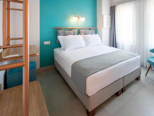 a bedroom with a bed and a blue wall at Meraki Bozcaada in Bozcaada