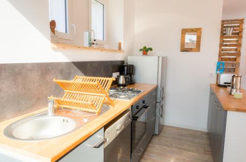 une cuisine avec un évier et un réfrigérateur dans l'établissement Vacances en famille a 250m de la mer a Penmarch, à Penmarcʼh