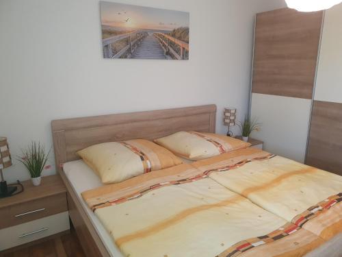 ein Schlafzimmer mit einem Bett mit zwei Kissen darauf in der Unterkunft Ferienwohnung H 12 in Graal-Müritz