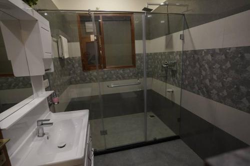 a bathroom with a glass shower and a sink at The Cerro Rico - 3 BHK Modern Villa in Kasauli