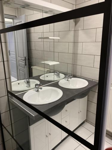 une salle de bain avec trois lavabos et un miroir dans l'établissement Très bel Appartement cosy proche de la gare et de l'hôpital - IMMOMMER, à Orval