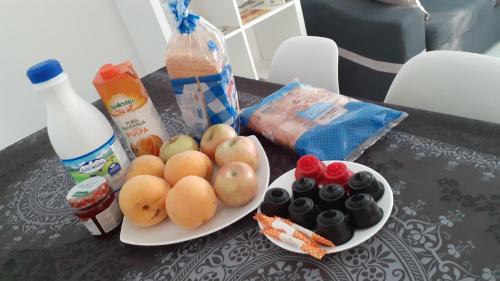 una mesa con dos platos de fruta y una botella de leche en Alcañiz Flats II, en Alcañiz