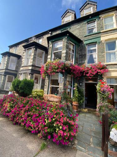 a house with lots of flowers in front of it at Rowan Tree Guest House in Keswick