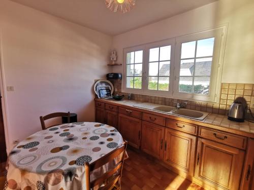 cocina con mesa, fregadero y ventana en Villa les Oyats, en Bréhal