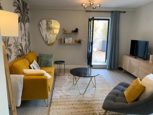 een woonkamer met een gele bank en een tafel bij Dans ma Bulle - Les Balcons de la Cité in Carcassonne