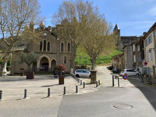 a street with cars parked in front of a building at Dans ma Bulle - Les Balcons de la Cité in Carcassonne