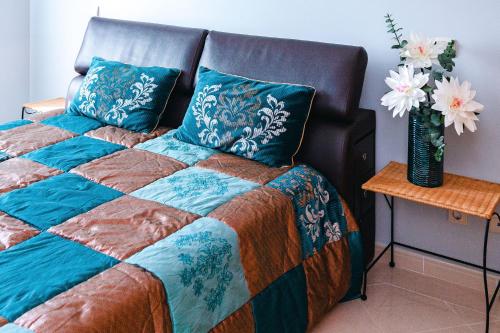 een slaapkamer met een bed met blauwe kussens en een tafel bij Tatiana 1 bedroom apartment in Albufeira