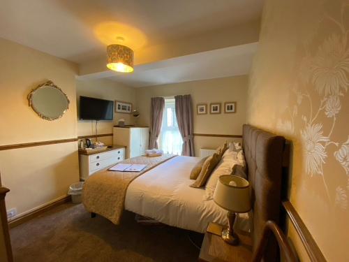 sypialnia z dużym łóżkiem i oknem w obiekcie Rowan Tree Guest House w mieście Keswick