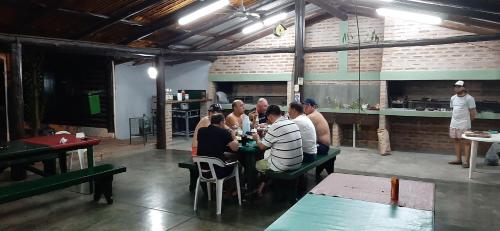 a group of people sitting at a table in a restaurant at Cabañas Los Troncos in Ituzaingó