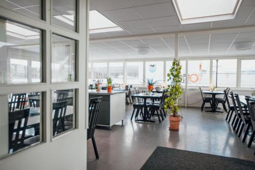 a dining room with tables and chairs and windows at Kajkanten Restaurang B&B in Köpmanholmen