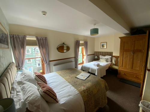 een hotelkamer met 2 bedden en een raam bij Rowan Tree Guest House in Keswick