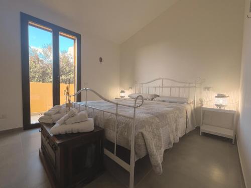 um quarto com uma cama e uma grande janela em Residence Oleandri- Oleandro Rosso em SantʼAnna Arresi