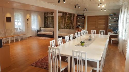 a living room with a large white table and chairs at Pähni külalistemaja in Rõuge