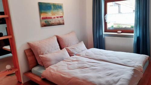 Bett in einem Zimmer mit Fenster in der Unterkunft Ferienwohnung "kleine galerie" in Königheim