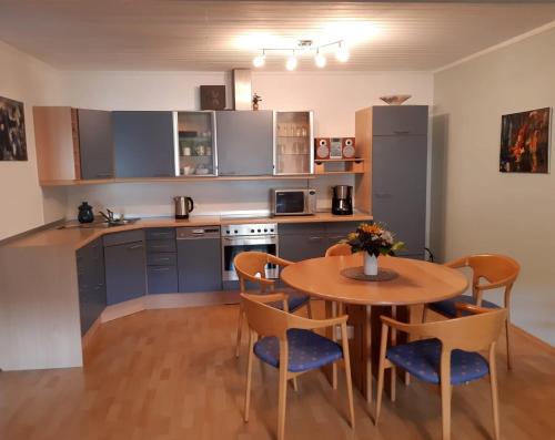 a kitchen with a wooden table and chairs and a table and a kitchen with at Ferienwohnung "kleine galerie" in Königheim
