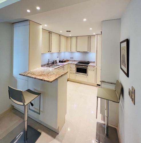 una cucina con mobili bianchi e un piano di lavoro di Residence Carlton Riviera a Cannes
