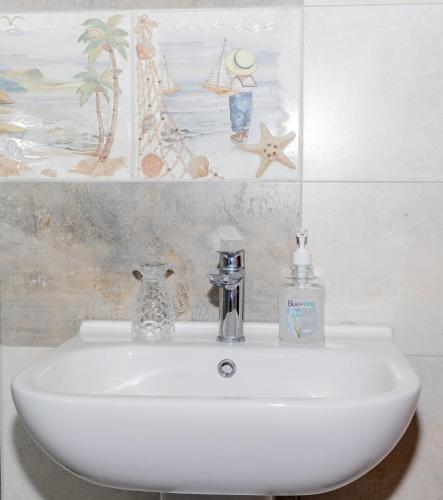 a bathroom sink with a bottle of soap on it at Enkarsis Resort Villa in Kitengela 