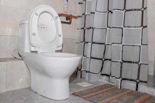 a white toilet in a bathroom with a shower at Enkarsis Resort Villa in Kitengela 