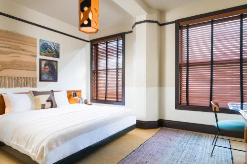 a bedroom with a large bed and windows at Freehand Los Angeles in Los Angeles