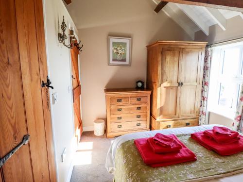 a bedroom with a bed with red towels on it at The Hayloft in Skegness