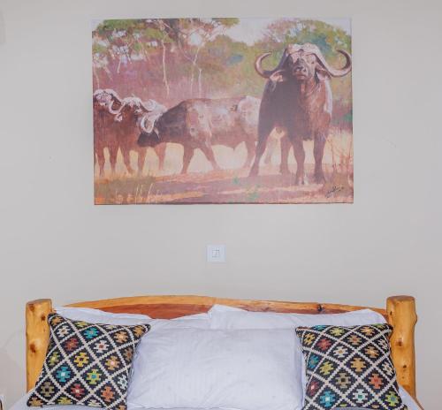 a painting of animals on the wall above a bed at Enkarsis Resort Villa in Kitengela 