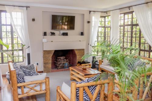 a living room with a fireplace and a tv at Enkarsis Resort Villa in Kitengela 