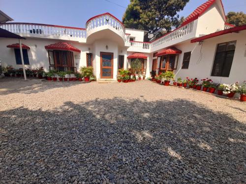 a large white house with a large driveway at Sukoon.Homestay in Rājpur