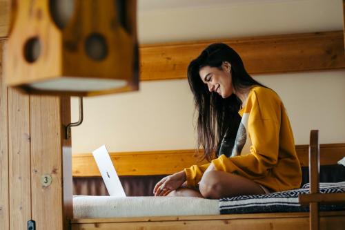 a woman sitting on a bed looking at a laptop at Freehand Los Angeles in Los Angeles