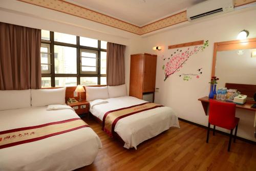 Habitación de hotel con 2 camas, escritorio y ventana en Nice Hotel, en Kaohsiung