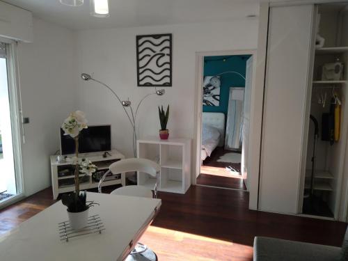 un salon avec une table et une chambre avec un lit dans l'établissement Joli T2 proche plages, à Bidart